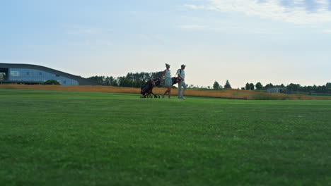 golf couple walking course outdoors. sport people examine country club fairway.