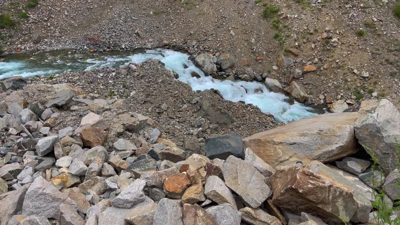 fotografía superior de una estrecha corriente de agua que pasa a través de montañas rocosas a lo largo de la ruta que conduce a las llanuras de deosai, skardu en pakistán