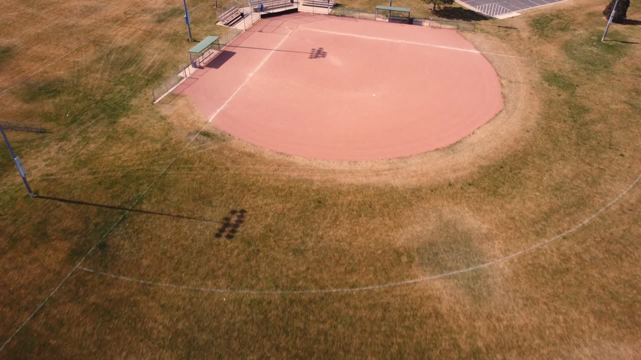 봄이 시작되고 직원들이 여름 스포츠 시즌을 준비할 때 작은 공공 커뮤니티 공원 야구장의 느린 비행 오버헤드 드론 샷