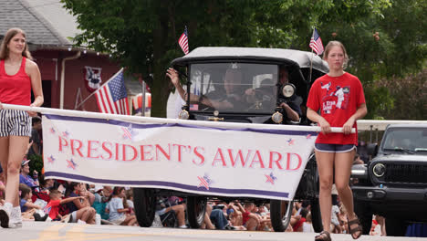 two girls holding the president's award banner during the july 4th parade in centerville, ohio, usa - medium shot