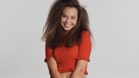 caucasian curly haired woman smiling to camara.