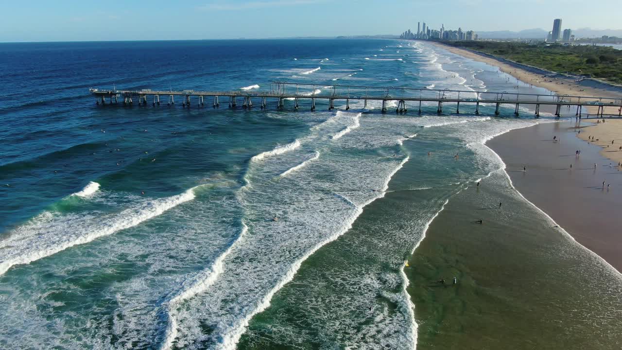 Hovering,looking along beaches and sand pumping jetty towards Surfers Paradise skyline, sunset