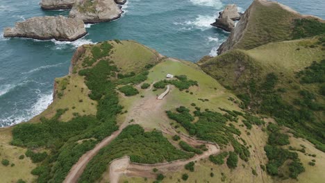 scenic aerial view of muelle de las almas amidst natural landscapes and ocean cliffs. circle dolly shot
