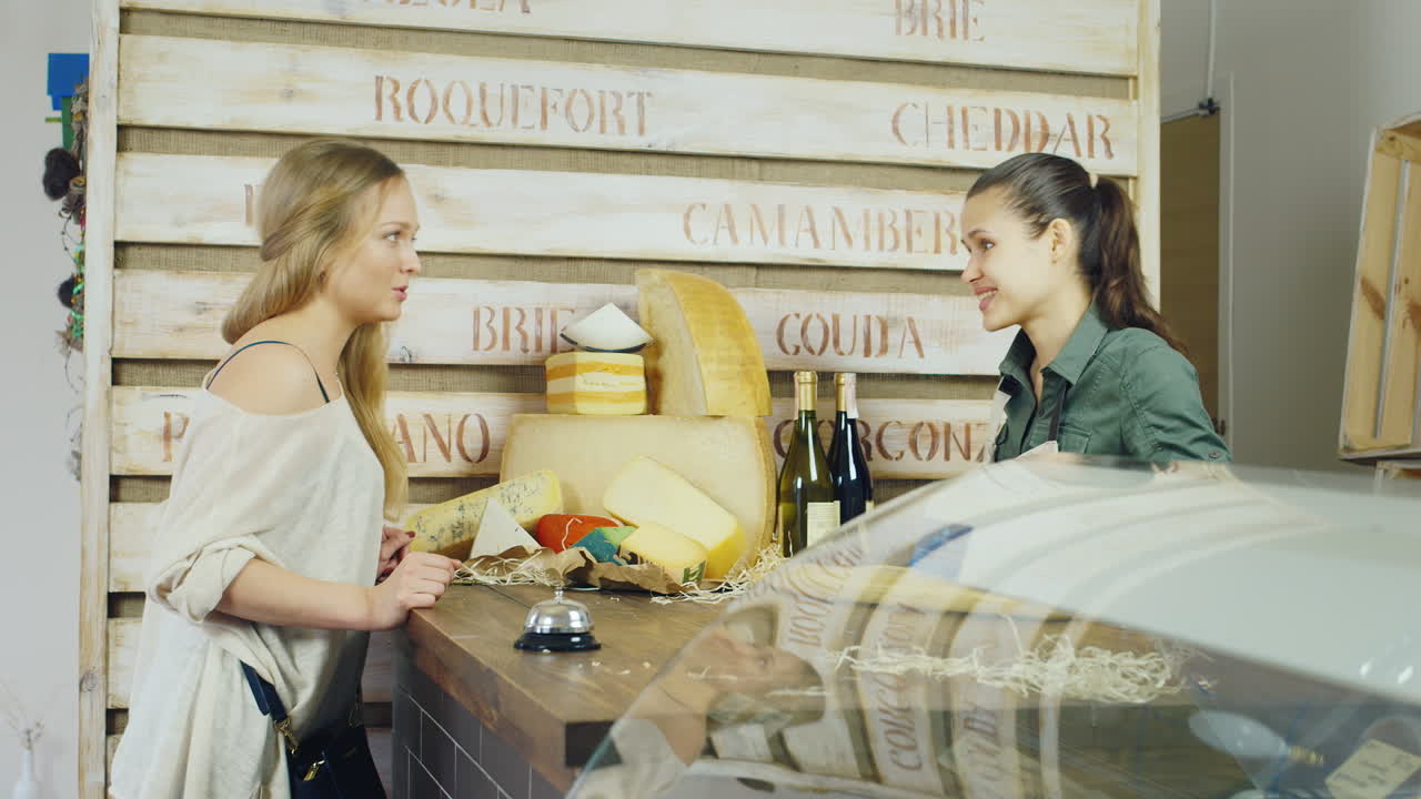 el vendedor en una pequeña tienda de comestibles está hablando con el comprador