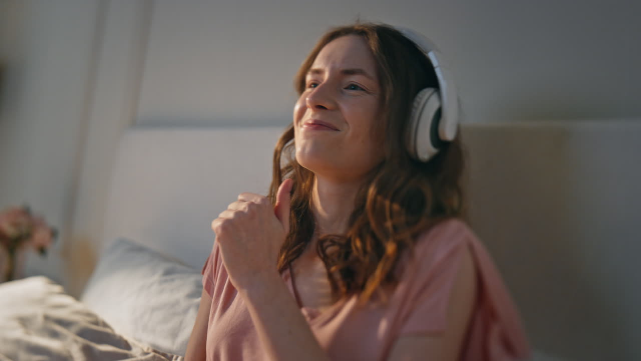 가까이에서 활기찬 소녀가 헤드폰으로 음악을 듣고 기하고 행복한 여성 춤