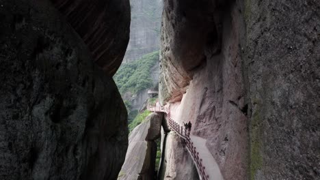 aerial: scenic hike on bajiao shan mountainside cave, china