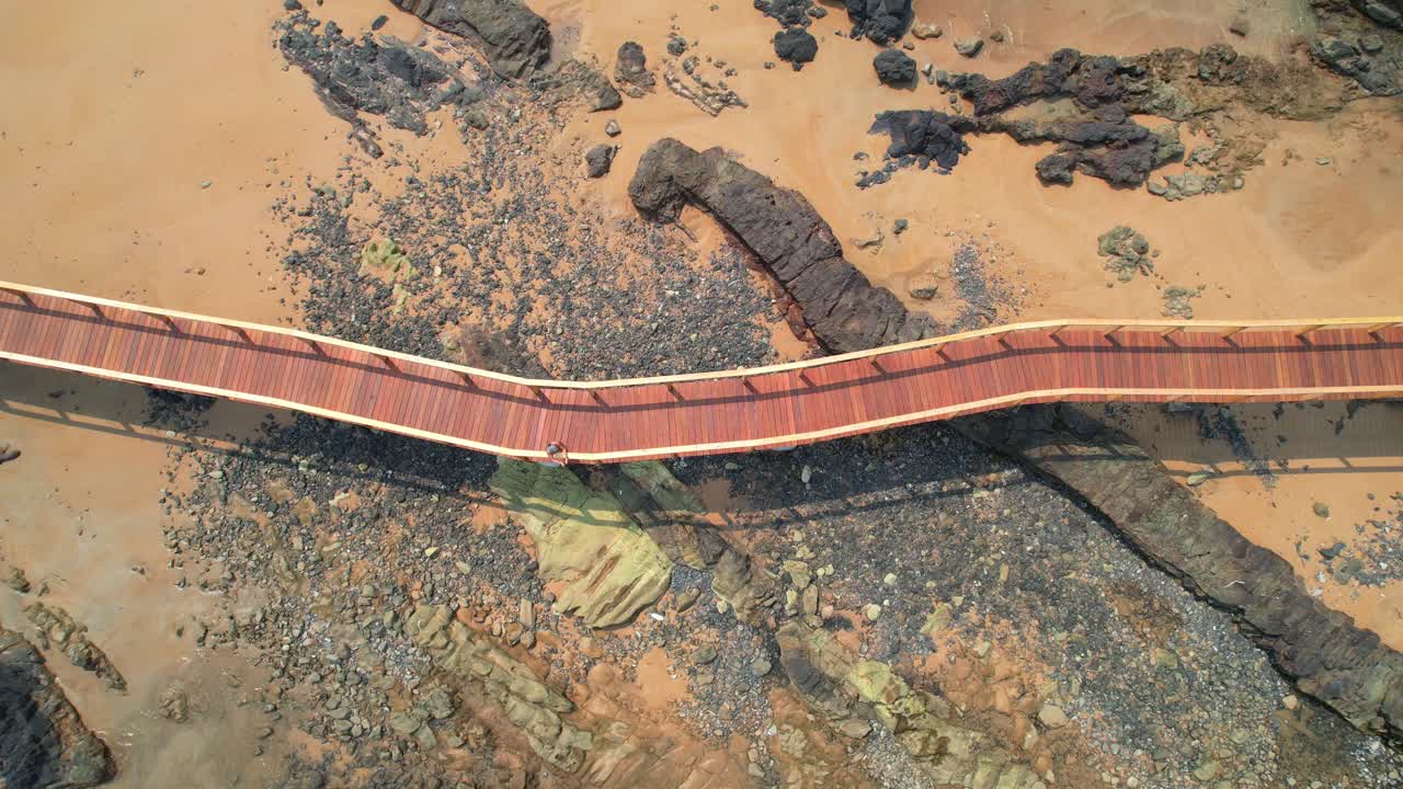 Aerial view of a woman walking on the walkway that connects Bom Bom islet and stopping to take photos at Prince Island,São Tomé,Africa