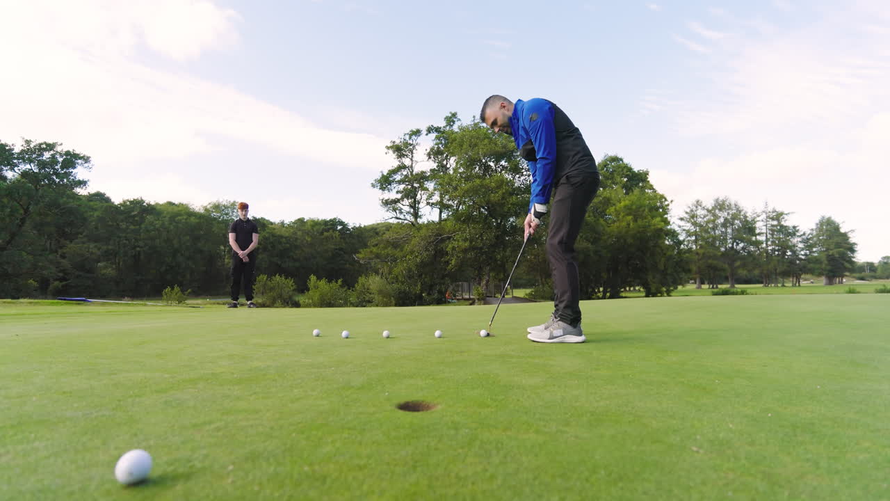 Two male golf players playing golf together, hitting balls with club on a golf course