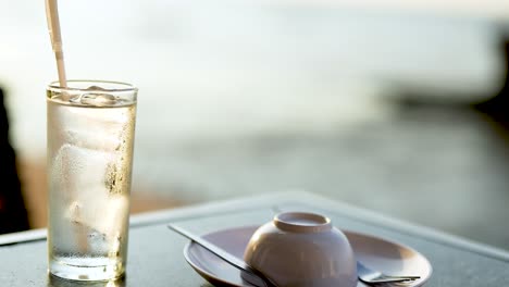 glass and dish on table by the sea