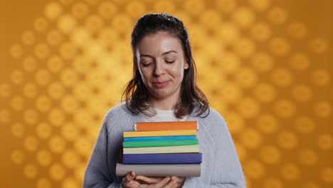retrato de una mujer feliz con una pila de libros en las manos mostrando los pulgares hacia arriba