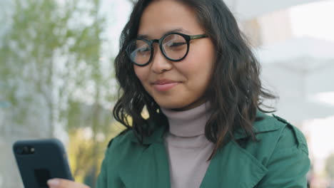 asian businesswoman using smartphone outdoors