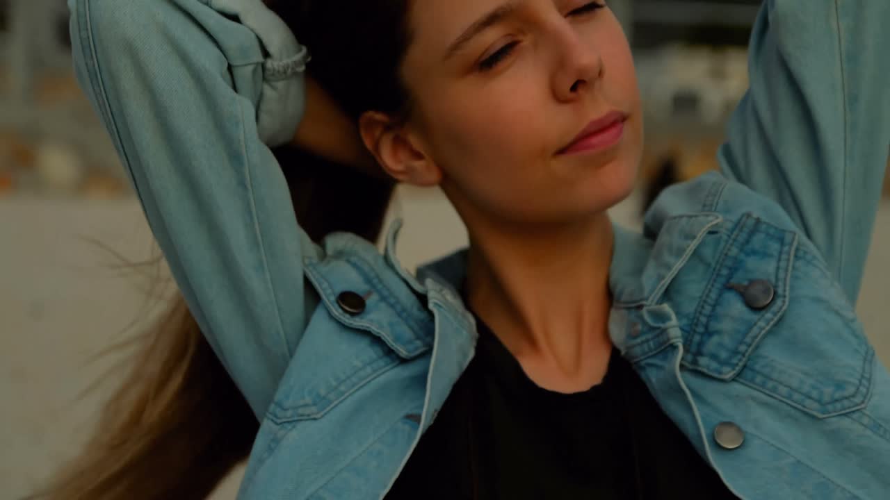 mujer atando su cabello mientras estaba sentada en la playa 4k