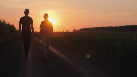 personas caminando por un camino de campo al atardecer