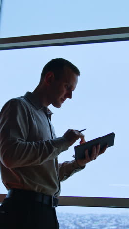businessman taking notes by window
