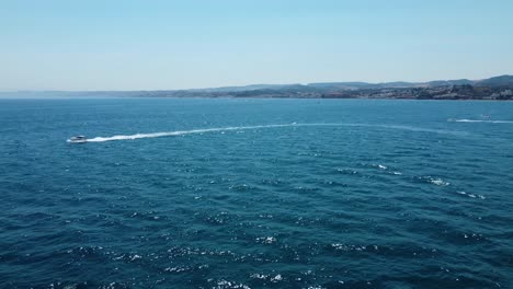 aerial drone tracking video of luxury yacht cruising in deep blue open ocean sea