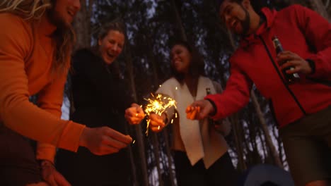 low angle view of friends having fun with sparklers in the forest 4k