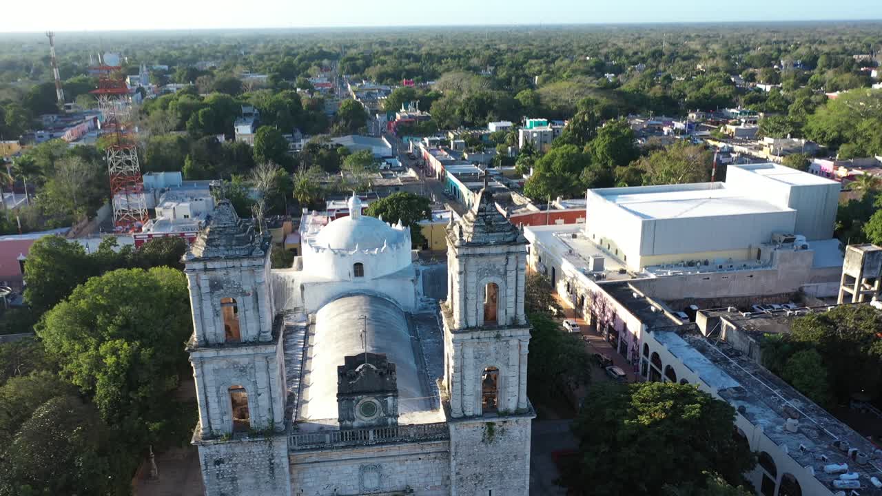 Dynamic aerial pull back and tilt up to reveal the Cathedral de San Gervasio after sunrise in Valladolid, Yucatan, Mexico
