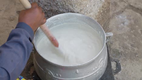 la mezcla para el banku se agita en una olla en una estufa hecha a mano, plato nacional ghanés