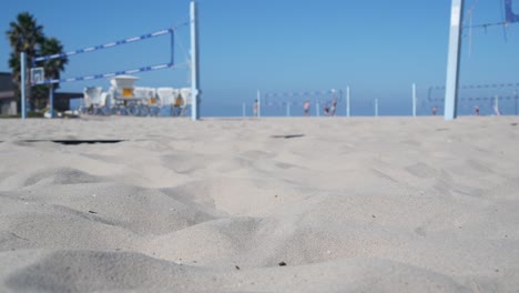 players playing volleyball on beach court, volley ball game with ball and net.