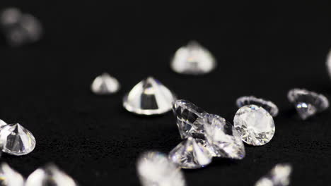 toma en cámara lenta de diamantes de corte brillante reales que caen sobre la mesa de clasificación negra en una joyería