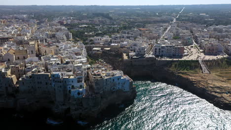 Wide-drone-shot-of-Lama-Monachile-in-Puglia,-Italy-with-a-bustling-beach-crowd