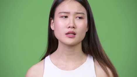 young beautiful asian businesswoman looking bored