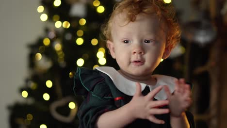 Baby-girl-clapping-her-hands-in-front-of-the-christmas-tree