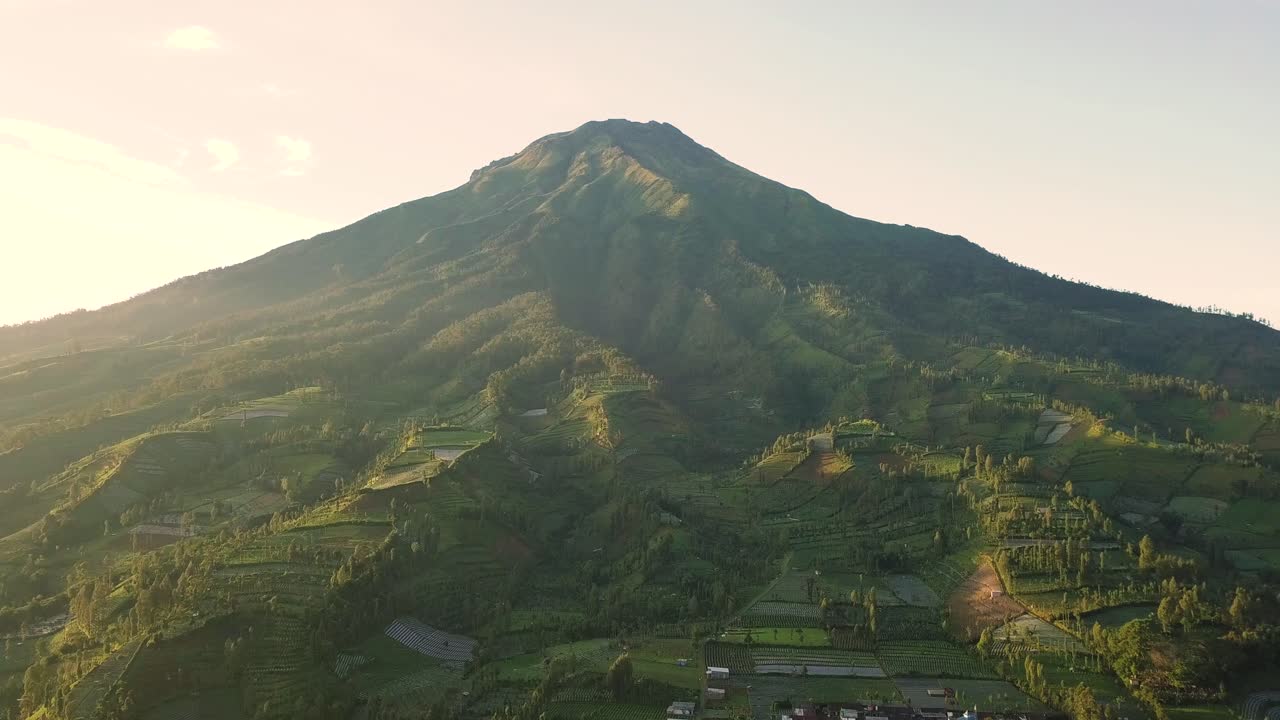 aerial shots from wonosobo region  indonesia of mount sumbing and the plantations on the mountain slopes and a village at the foot