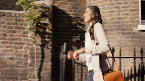 mujer caminando por la calle de la ciudad comprobando la hora