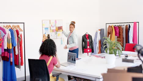 Happy-diverse-female-fashion-designers-with-laptop-in-discussion-at-studio,-copy-space,-slow-motion