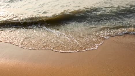 ocean waves crash on the sandy beach in pattaya, thailand