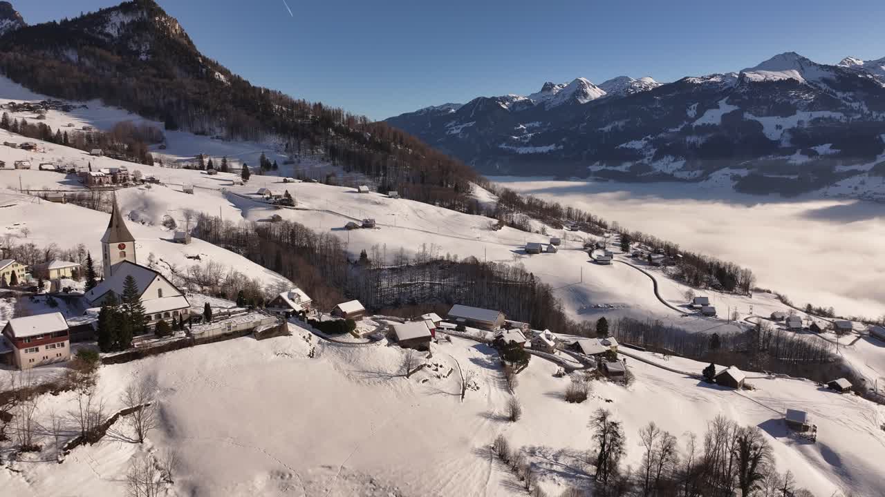 Village of Weesen with church and houses on the hill. Snowy fairy tale landscape in beautiful nature from drone view