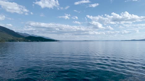 aerial low view of the water of the flat head lake in montana on a sunny day