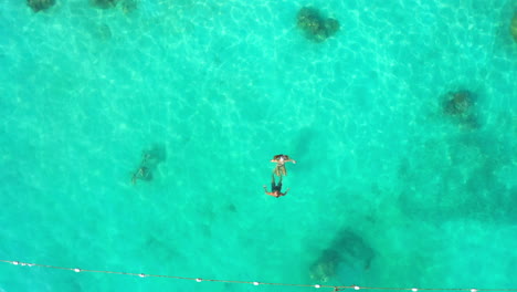 a-young-couple-swimming-together-out-at-sea