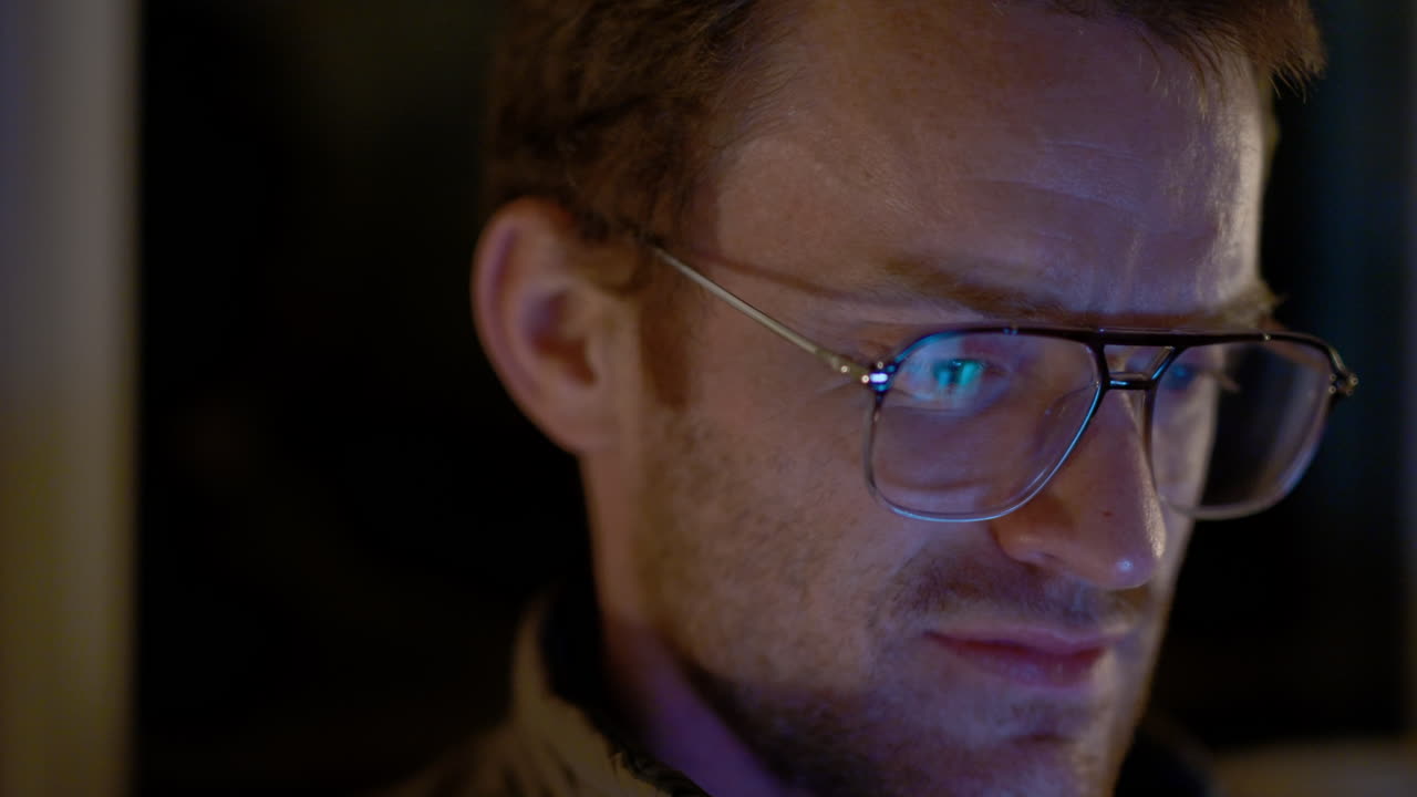 un hombre se ríe de un espectáculo que está viendo y bebe de su copa de cóctel