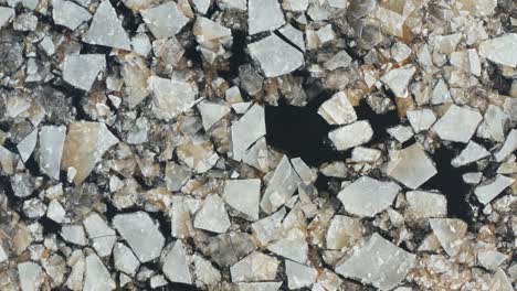 beautiful aerial fly over view of cracked ice floes floating in the sea