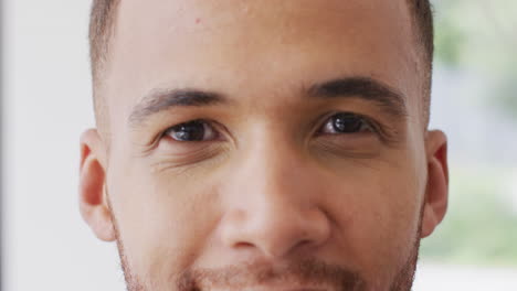 retrato en primer plano de un hombre biracial sonriendo a la cámara en el interior