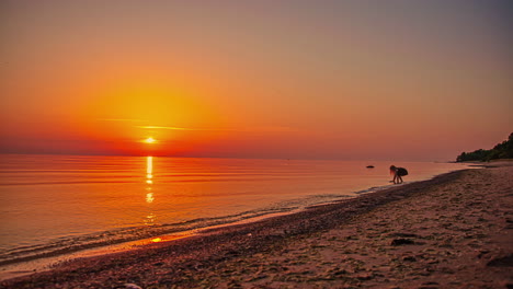 una puesta de sol dorada de ensueño que se refleja en la superficie cristalina del océano - lapso de tiempo de playa