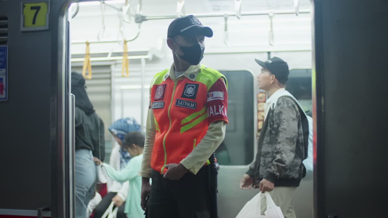 Indonesian security guard alert in railway station as passengers board train