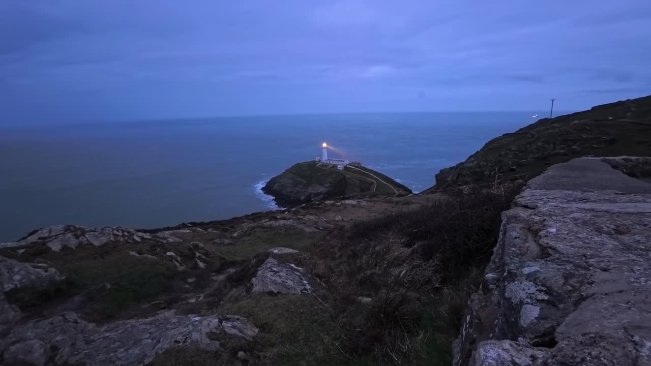 Time lapse av South Stack fyr, med roterende lysstråle over Irskesjøen om natten.