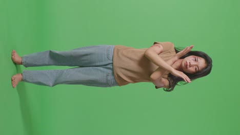 몸에 이 있는 젊은 아시아 여성의 몸이 카메라를 바라보고 녹색 스크린 배경 스튜디오에서 폭력을 멈추기 위해 손을 는 것을 보여줍니다.