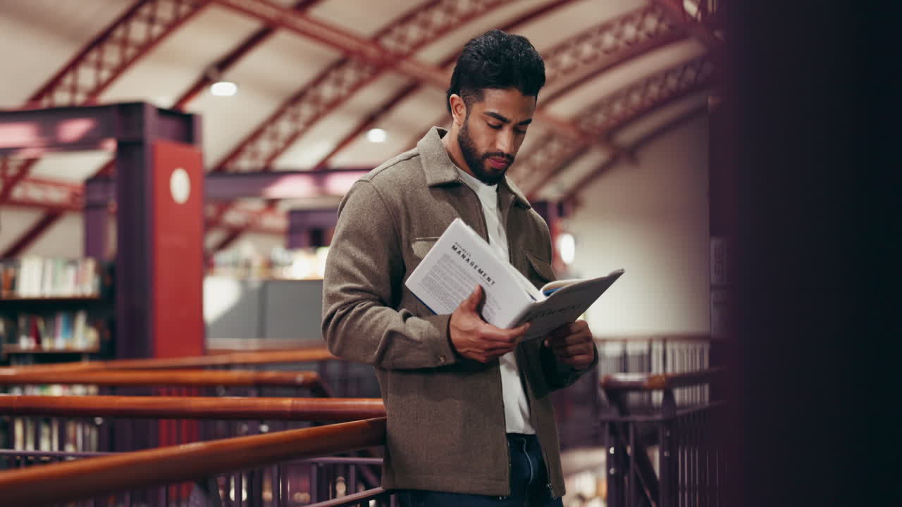 Mand læser ledelsesbog i et bibliotek