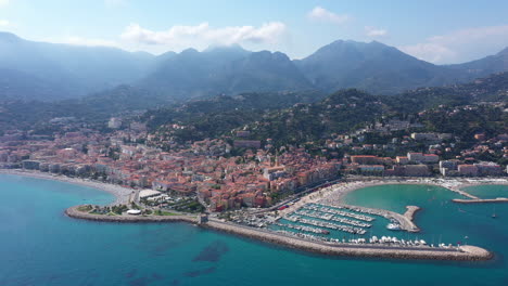 menton aerial shot over the city harbor and alps mountains in background france