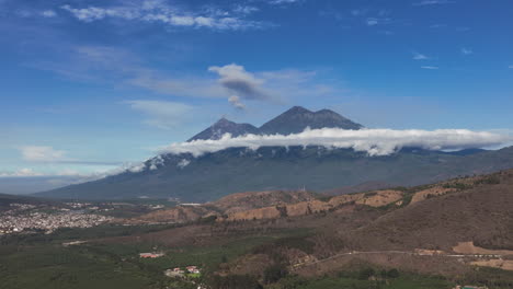 Slow-zooming-in-aerial-of-the-two-volcanoes-next-to-Antigua,-Fuego-and-Acatenango