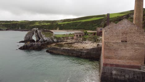 porth wen aerial view orbiting abandoned victorian industrial brickwork ruined factory remains on anglesey eroded coastline