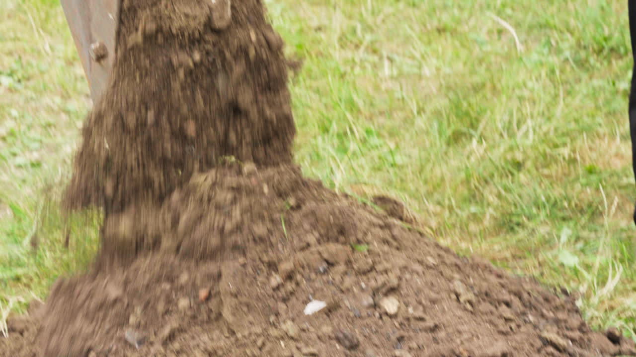 Primo piano della benna di un escavatore che rimuove il terreno e lo sposta dall'altra parte