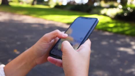 persona escribiendo por teléfono en un entorno al aire libre