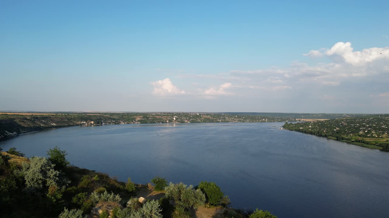 드론이 드네스터 강의 반사되는 물의 평온함과 시골의  ⁇ 과 숲의 활기찬 초록색과 노란색 색조를 날아다니며, 4k 조류의 시야