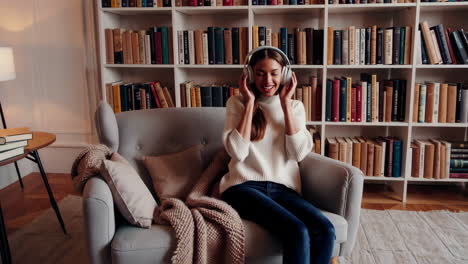 woman listening to music in a cozy home library