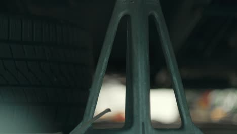 rack focus of jack stand supporting vehicle tire during auto repair